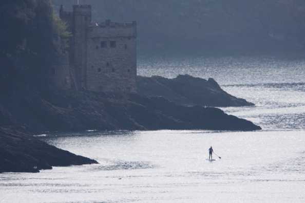 27 April 2020 - 10-01-25 
Quite a way out, all on their own. At peace. A paddleboarder (or paddle boarder as my spellcheck will have it) checks out the river mouth at Dartmouth.
----------------------
Kingswear Castle paddle boarder
